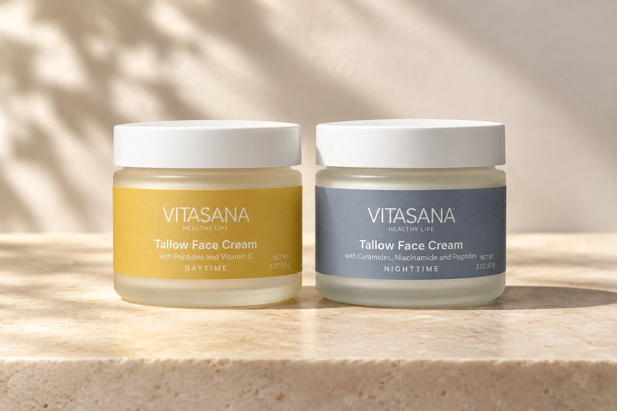 Vitasana Tallow Day Face Cream in yellow and Tallow Night Face Cream in slate blue, side by side on a warm stone surface